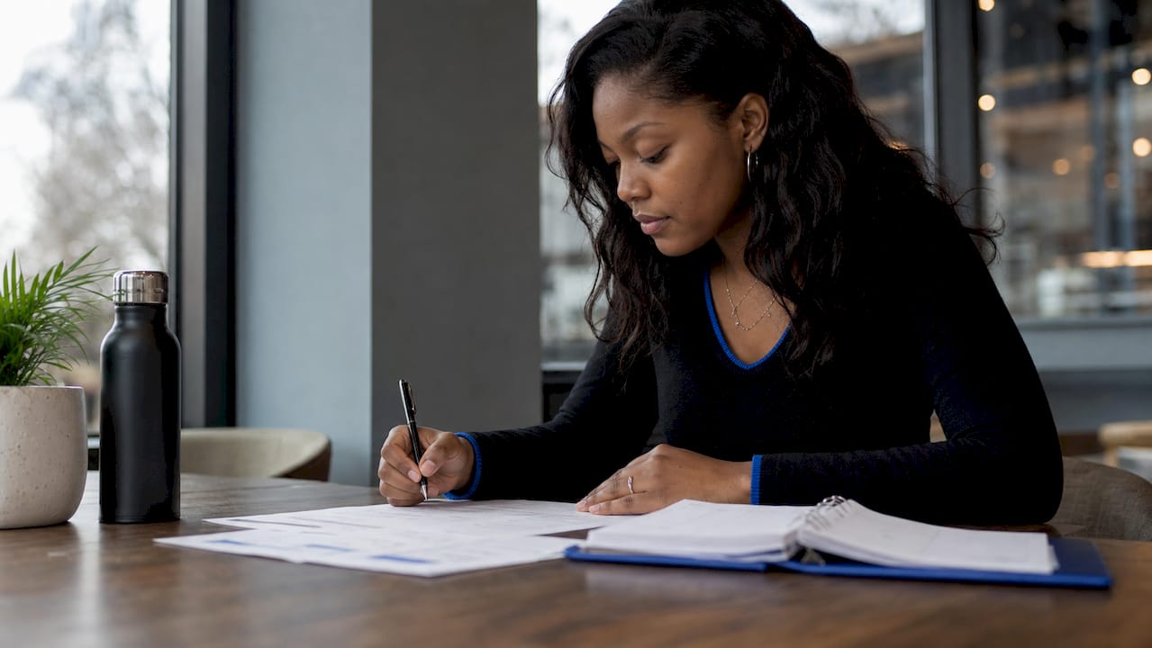 Woman reviewing client payment documents at desk